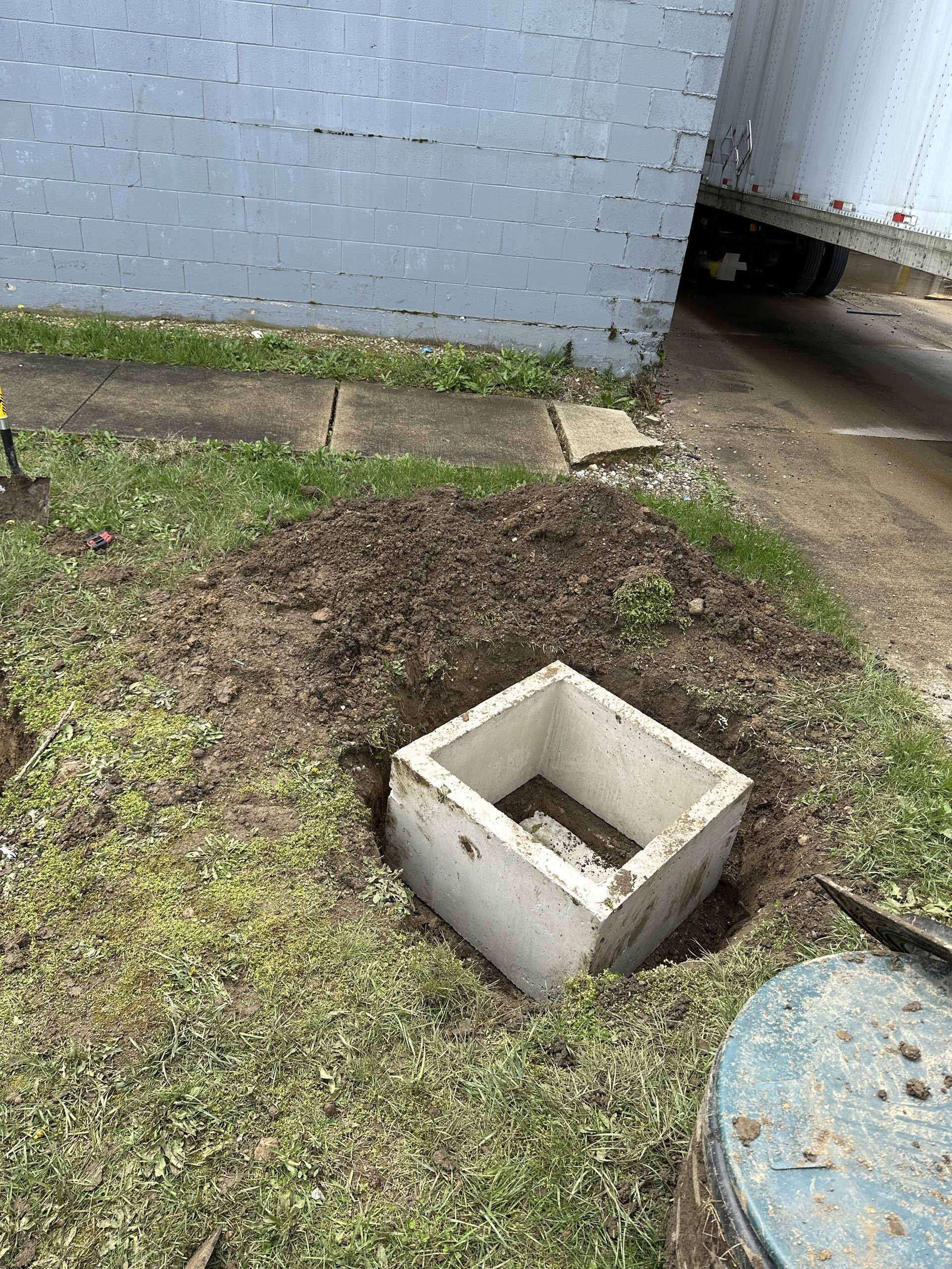 A concrete block is sitting in the middle of a hole in the ground.