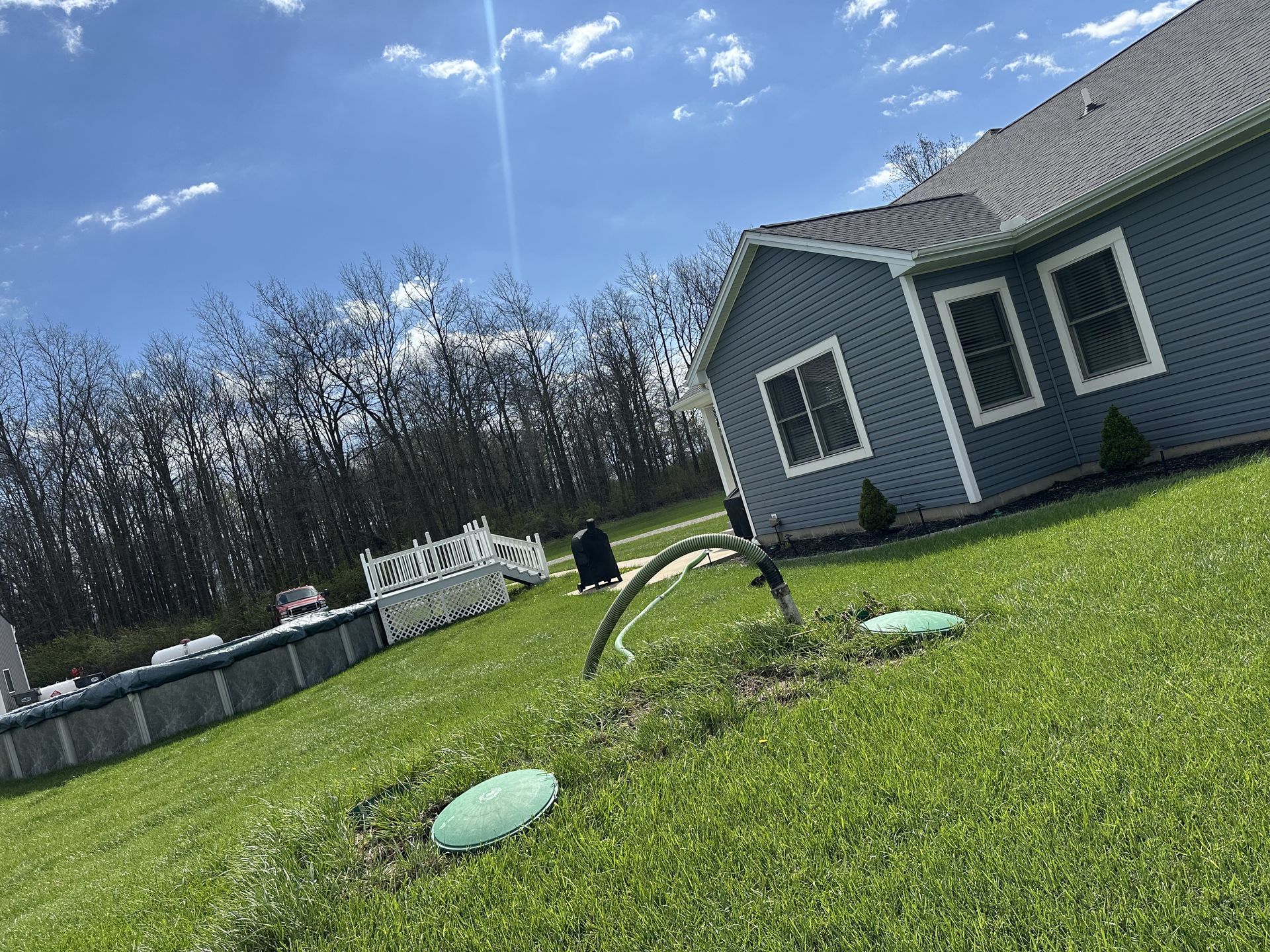 A house is sitting in the middle of a lush green field.