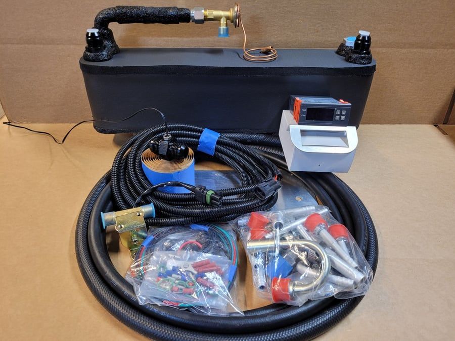 Black tank with hose, coiled cables, and small parts laid out on a table.
