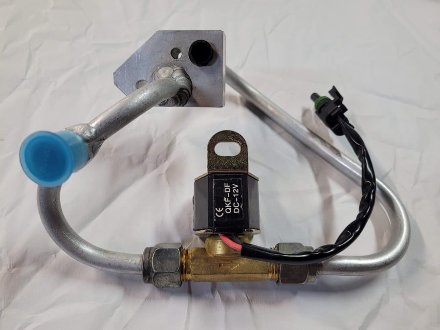 Metal valve assembly with blue cap, black solenoid, and braided wire on a light background