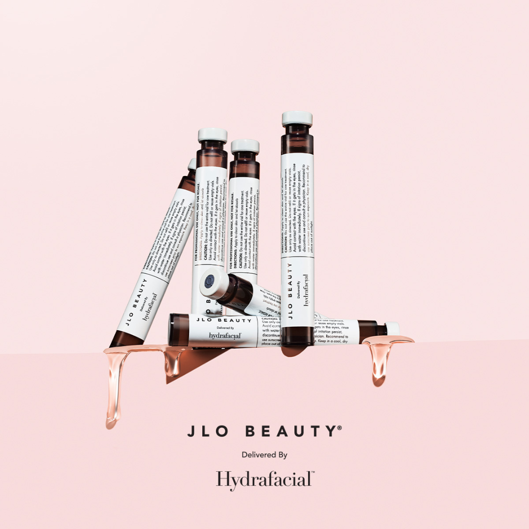 Eine Gruppe Flaschen, die übereinander auf einer rosa Oberfläche stehen.