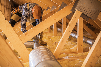 A man is working on the attic of a house.