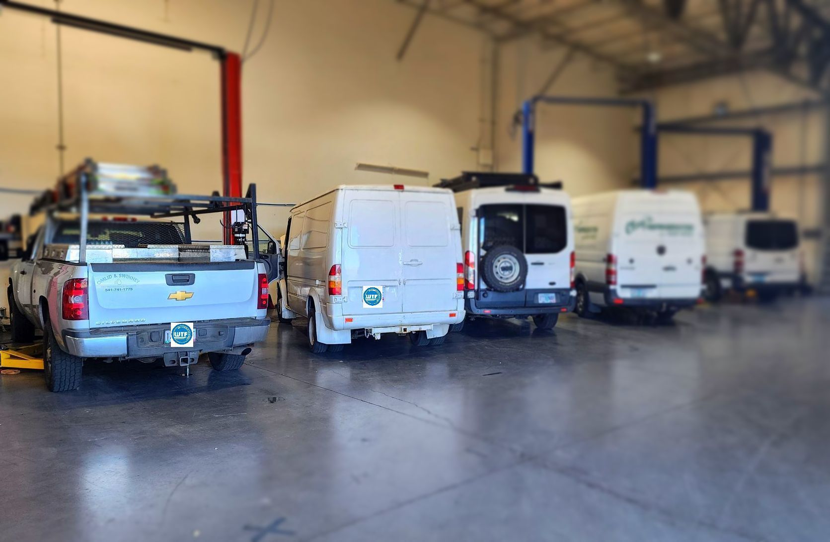 A workshop with service vans and a truck | Willamette Automotive Care