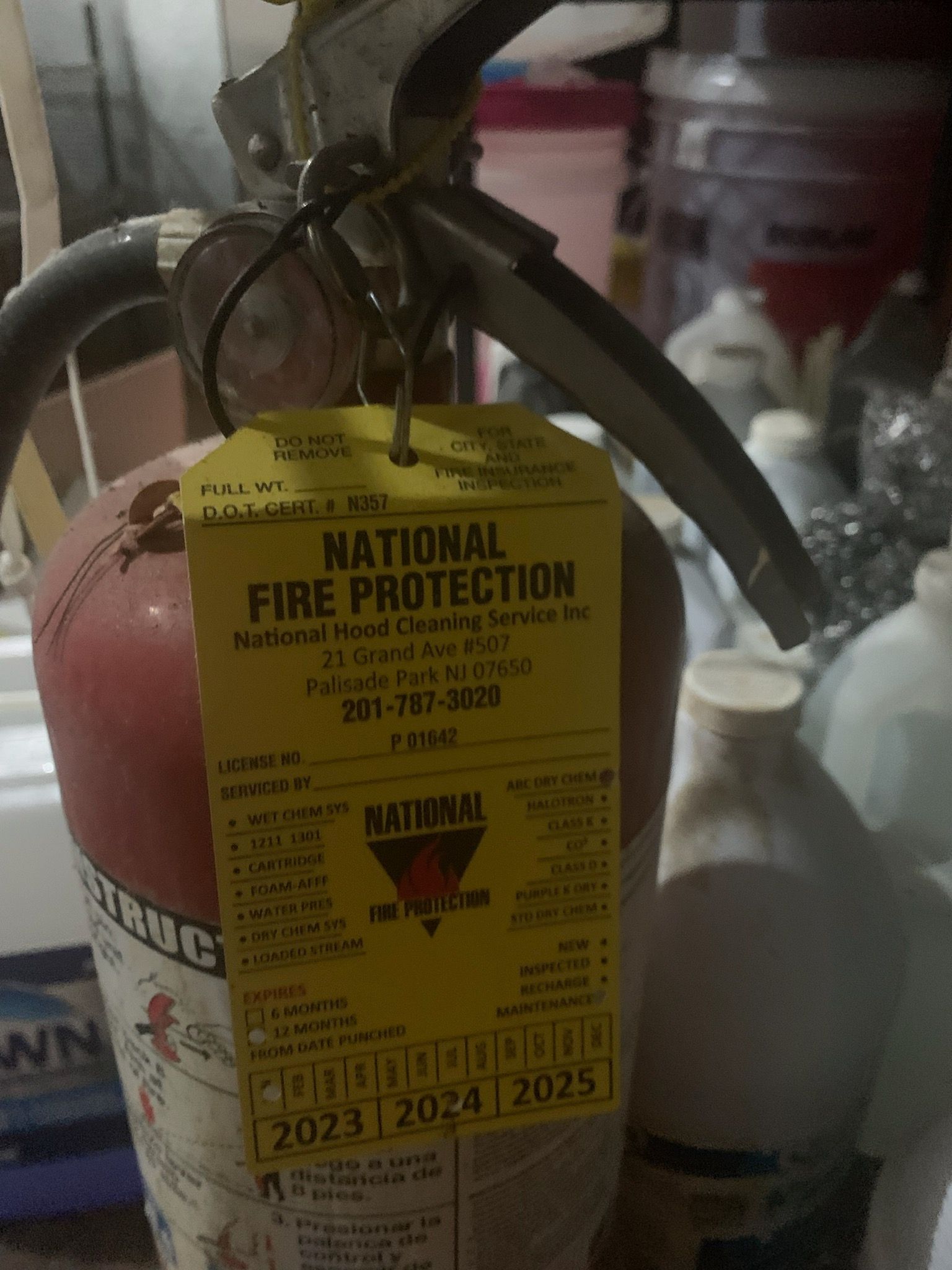 A fire extinguisher with a yellow tag that says national fire protection