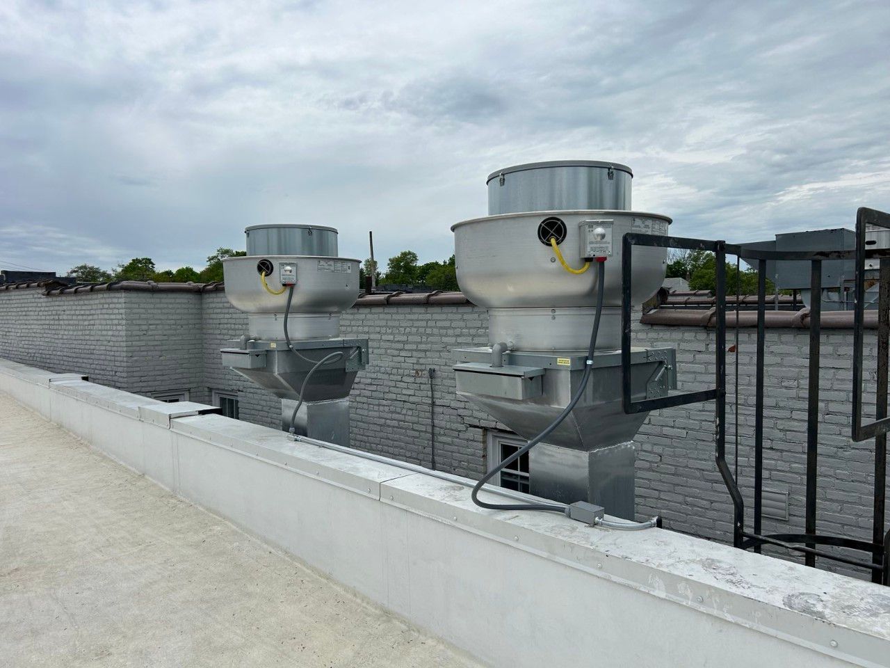 There are two exhaust fans on the roof of a building.