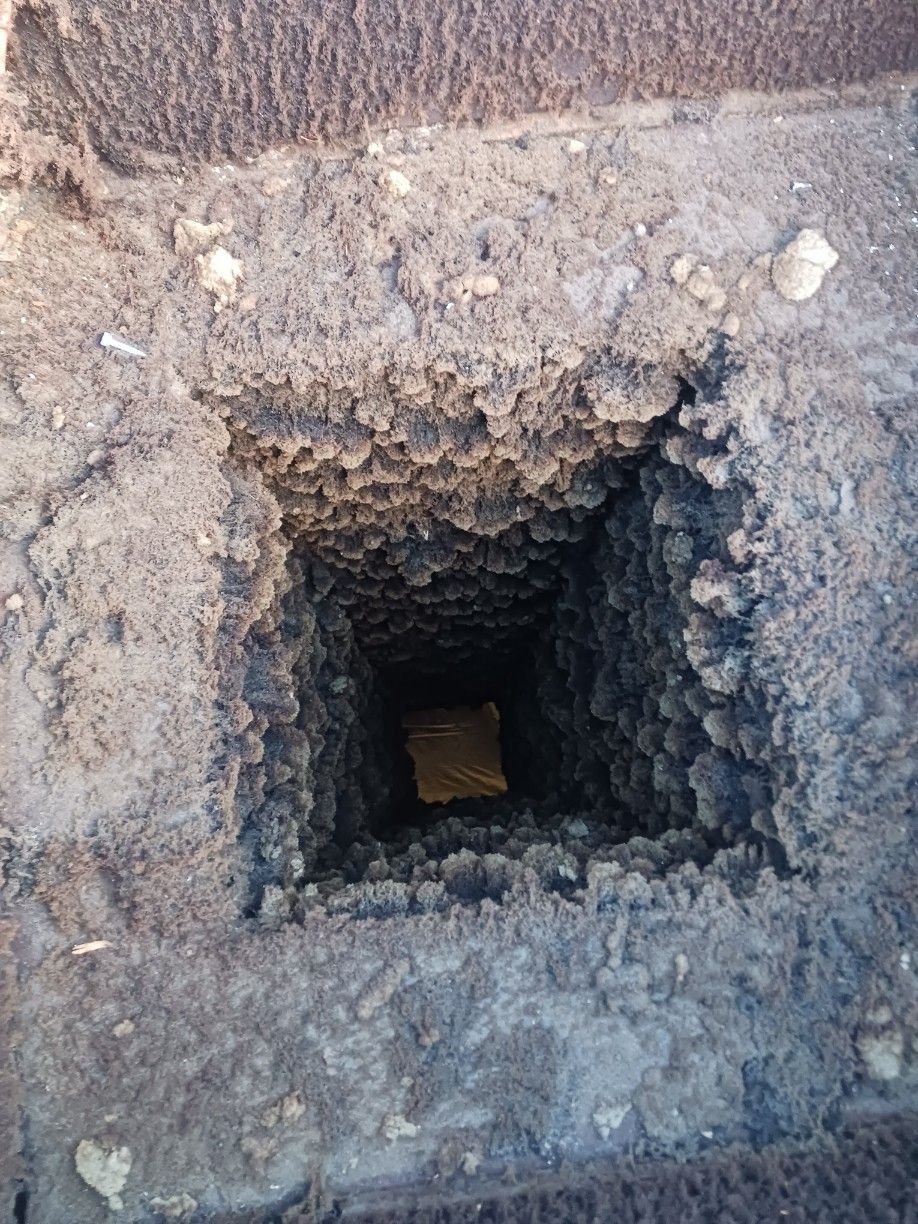 A hole in the ground with a piece of wood in it.