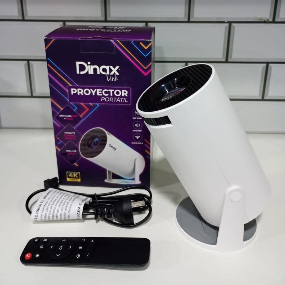 Proyector portátil Dinax Link de color blanco con caja, mando a distancia y cable de alimentación sobre superficie blanca.