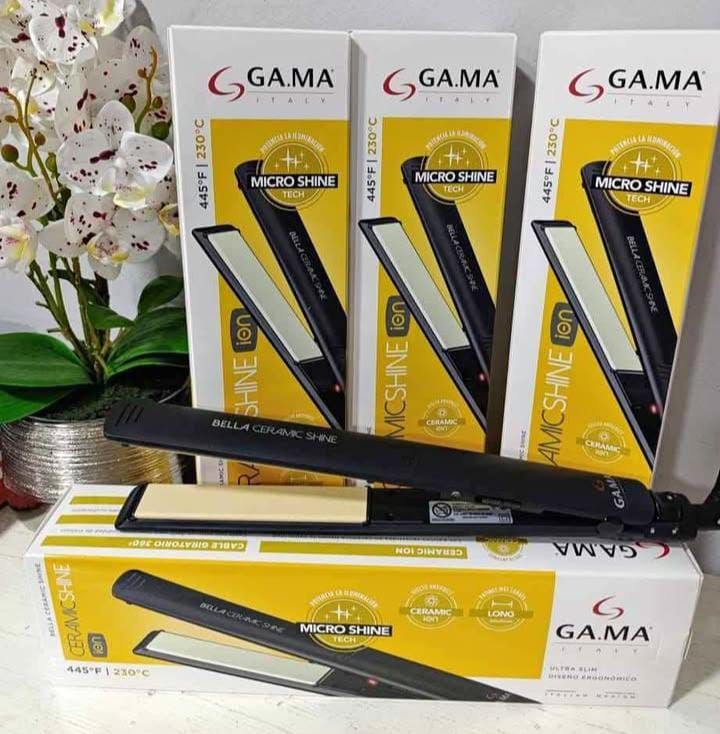 Varias cajas de planchas de pelo GAMA con una plancha sobre una caja delante de ellas.