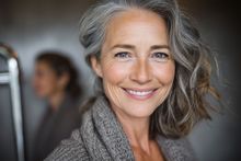 A woman is holding her hand to her face because she has a toothache.