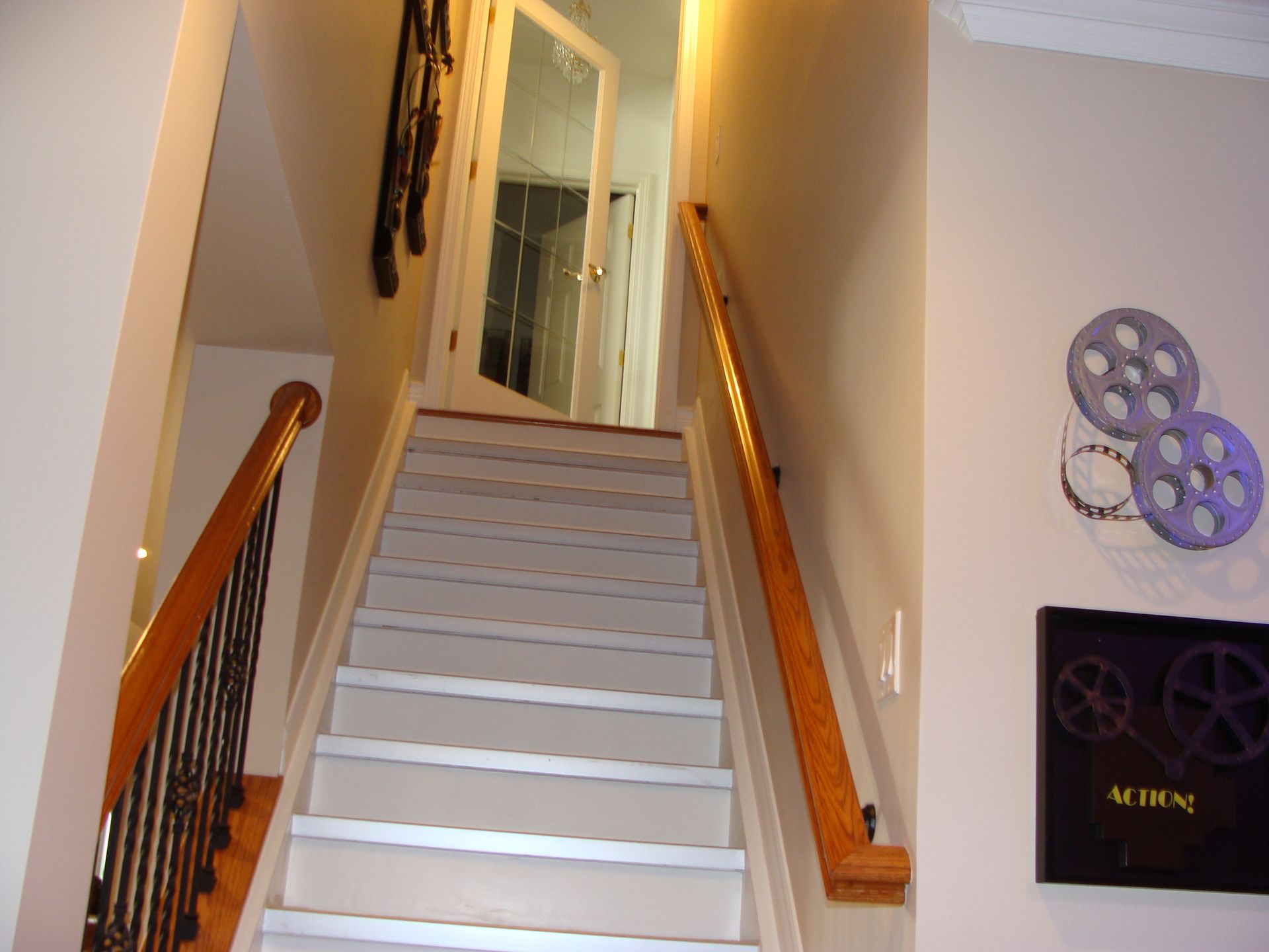 Staircase leading upwards, with painted steps, wooden handrails, and a door at the top.