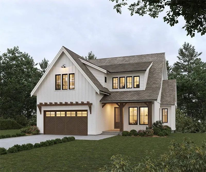 Two-story white farmhouse with brown trim and garage, set in a green yard under a cloudy sky.