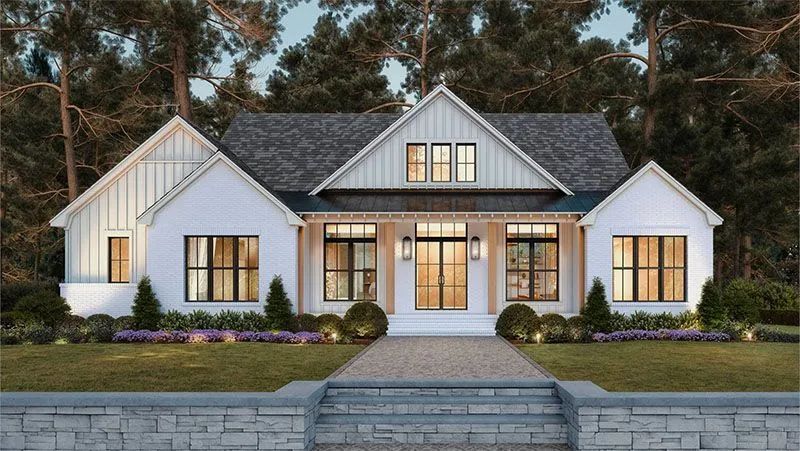 White farmhouse with dark windows and a stone walkway.