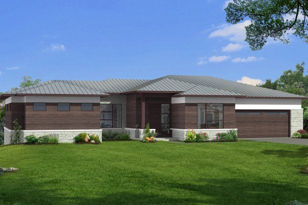 Modern one-story house with brown wood siding, gray roof, and green lawn under a blue sky.