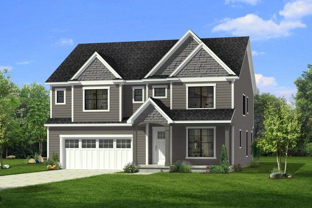 Two-story house with gray siding, white garage door, and a front porch, set on a green lawn under a blue sky.