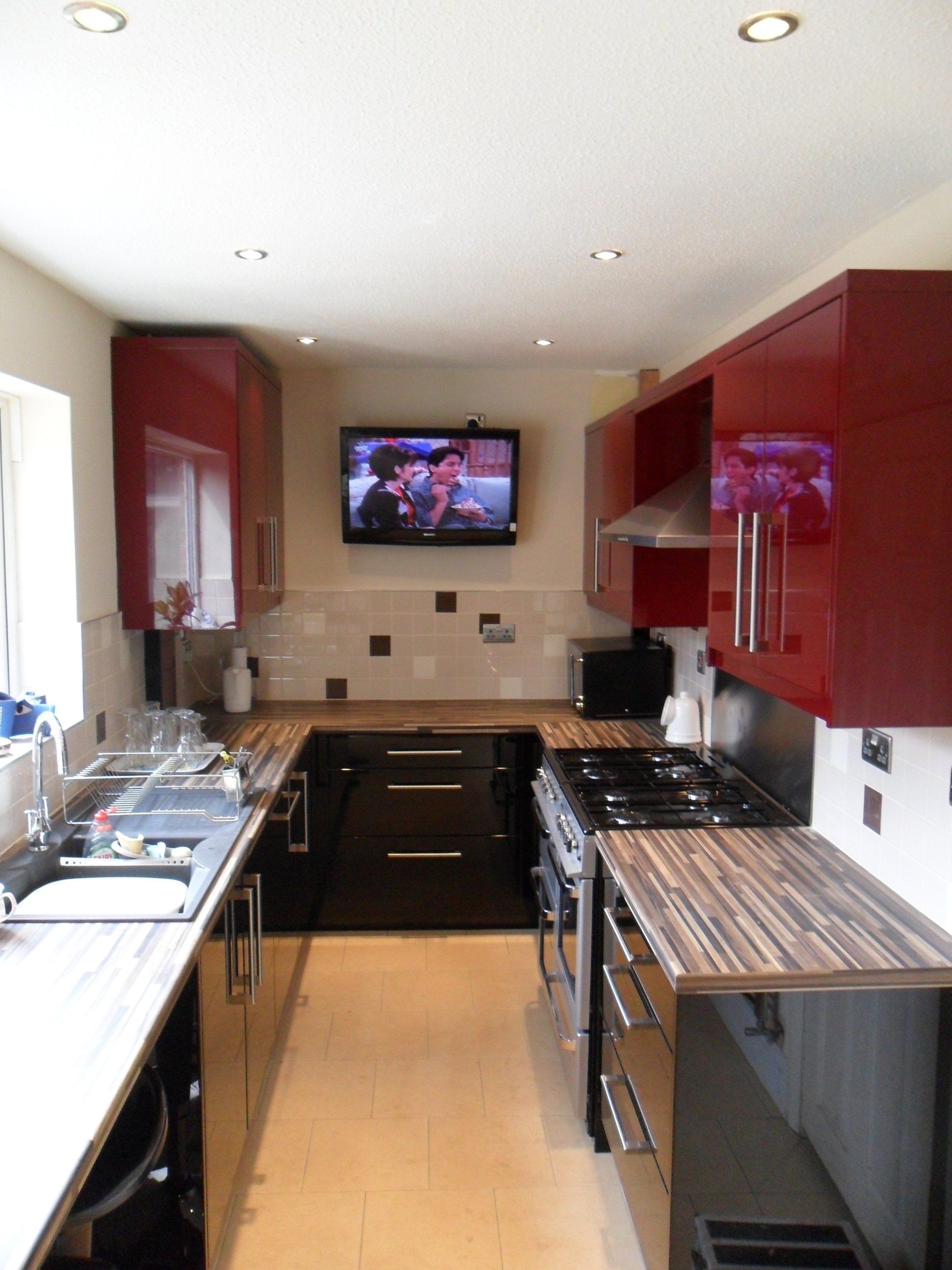 new kitchen cream wall tiles gloss burgundy red gloss black cabinets Axiom worktop. wall tv
