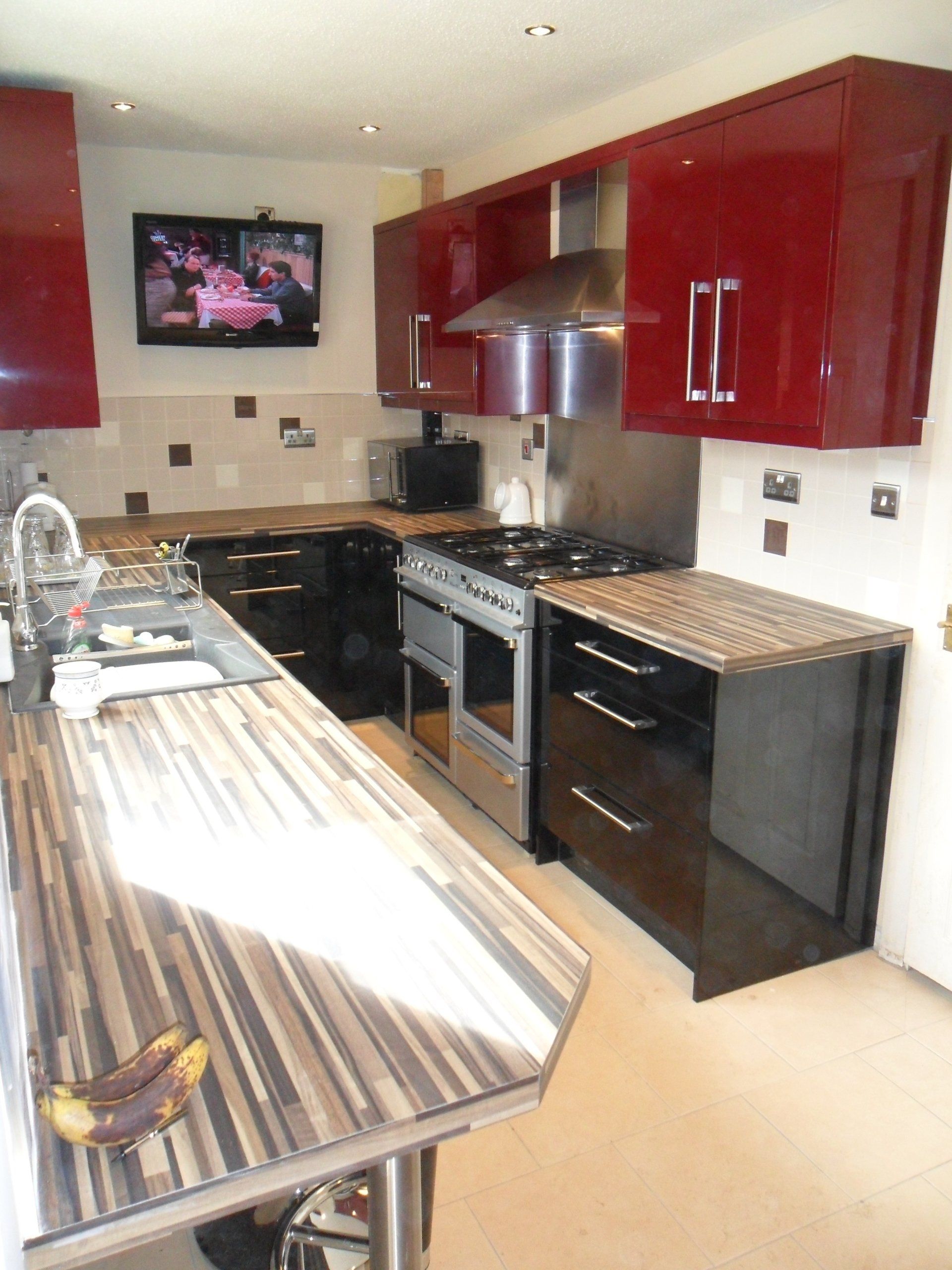 new kitchen cream wall tiles gloss burgundy red gloss black cabinets Axiom worktop bananas. wall tv
