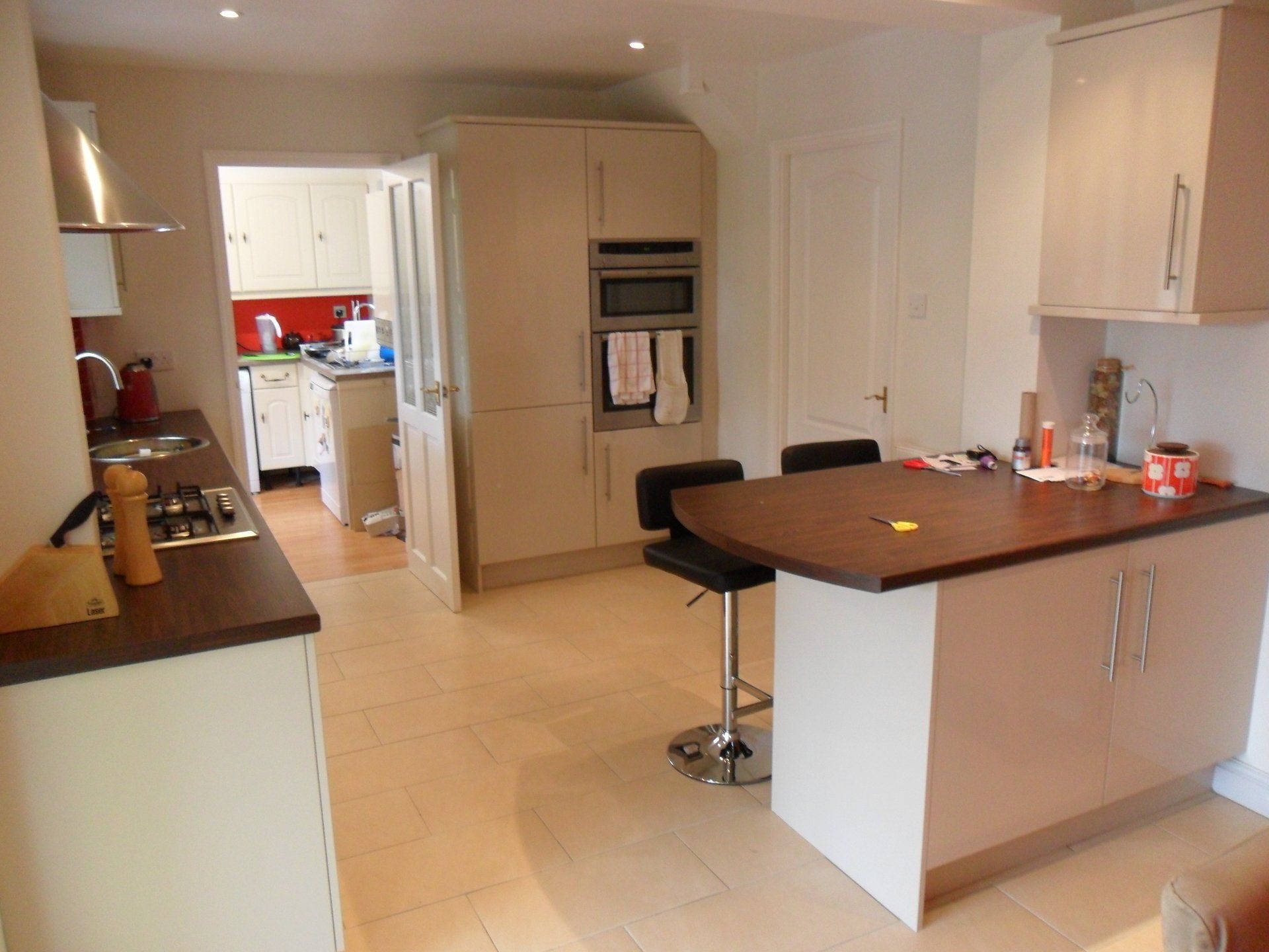 new kitchen bright red wall tiles gloss cream cabinets Axiom worktop cream floor tile