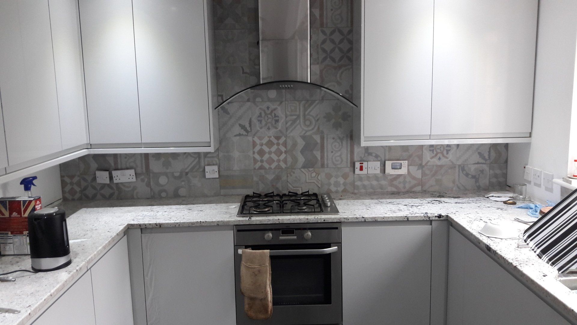 new kitchen white granite worktop grey gloss cabinet door patterened wall tile
