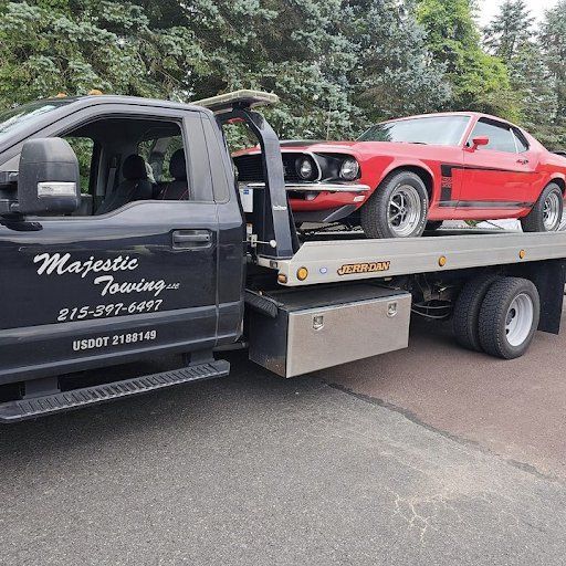 A red mustang is sitting on the back of a tow truck.