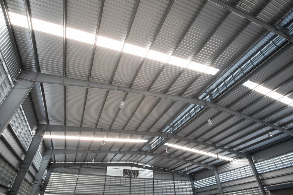 The Inside of a Large Warehouse With a Metal Roof — Timms Roofing In Barrack Heights, NSW