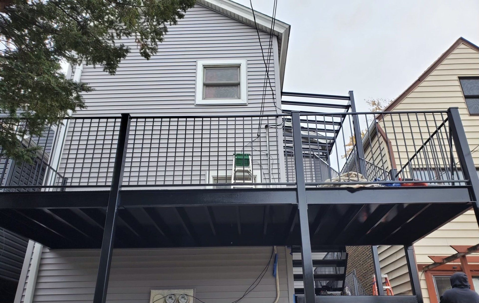 The back of a house with a balcony and stairs.