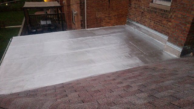 A roof with a white roof and a brick building in the background.