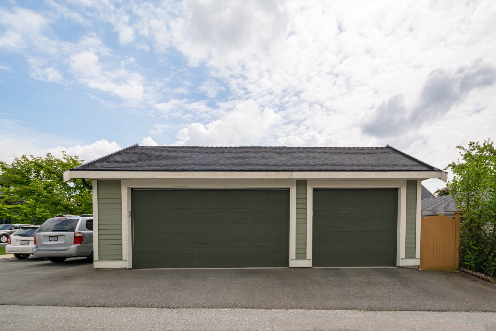 A garage with two cars parked in front of it.