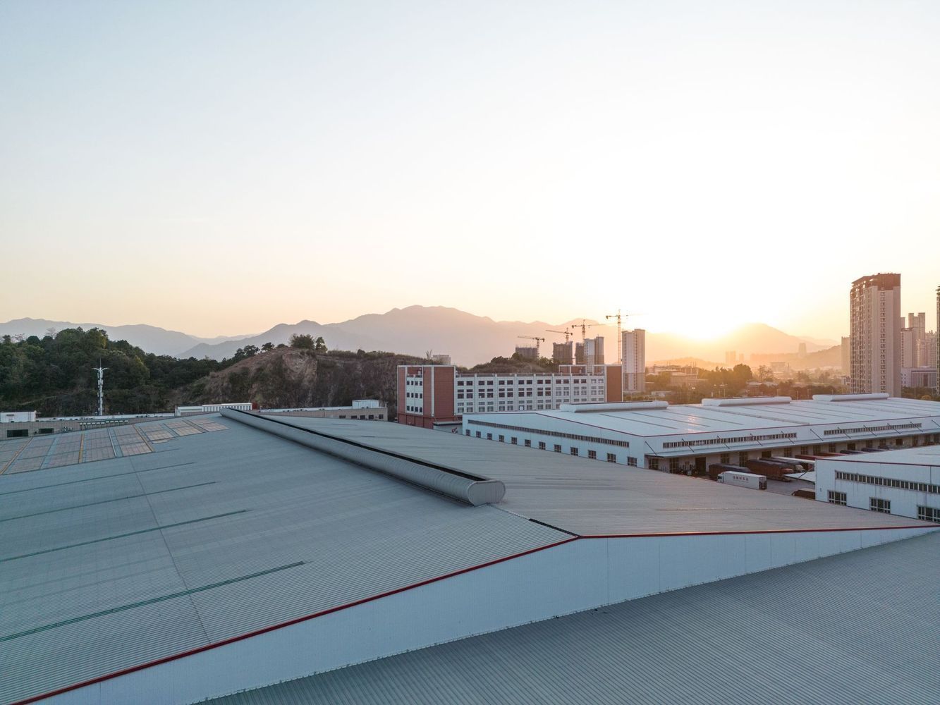 A view of a city from the roof of a building at sunset.