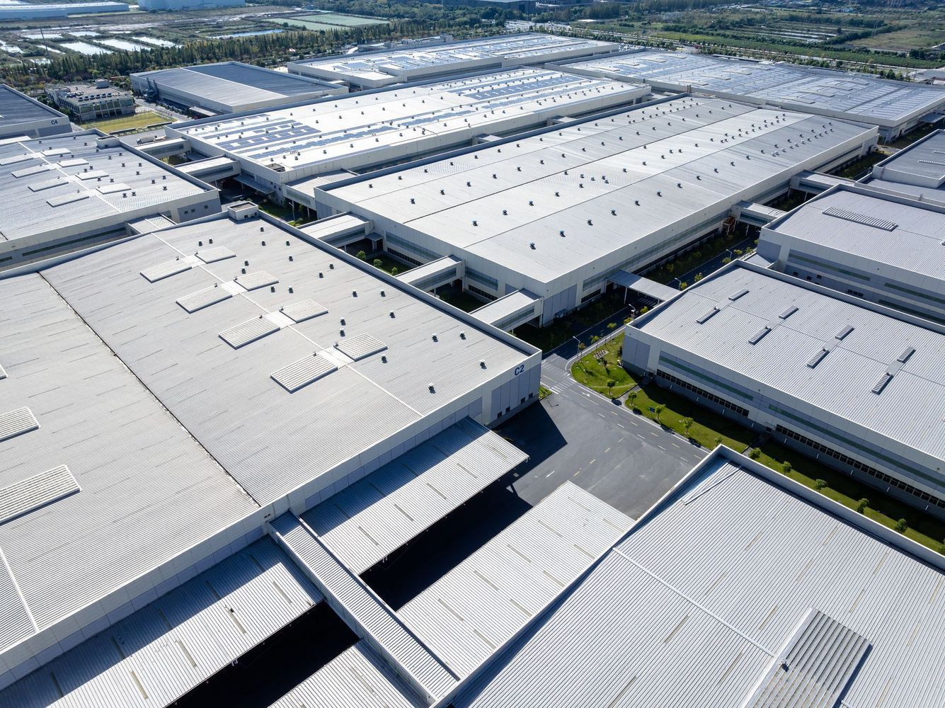 An aerial view of a large industrial area with lots of buildings and roofs.