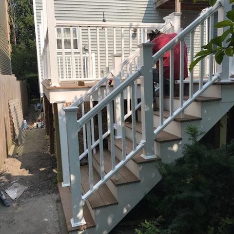 A man is standing on a set of stairs with a white railing