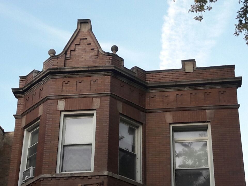 A brick building with a roof that has the letter r on it