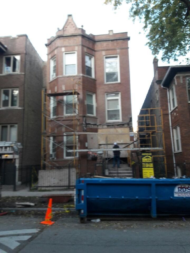 A blue dumpster with a yellow sign that says ' scaffolding ' on it