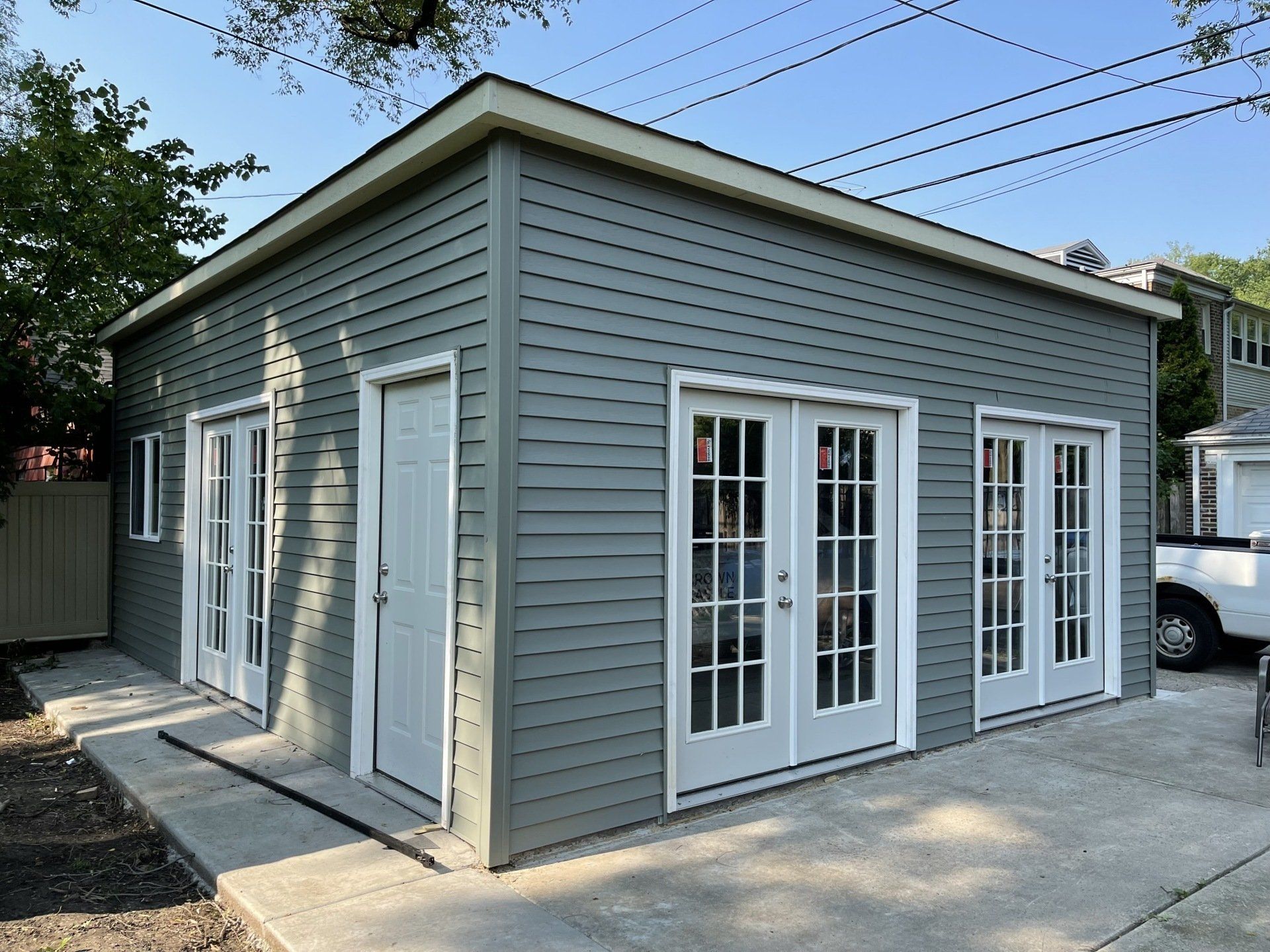 A garage with french doors and a white truck parked in front of it