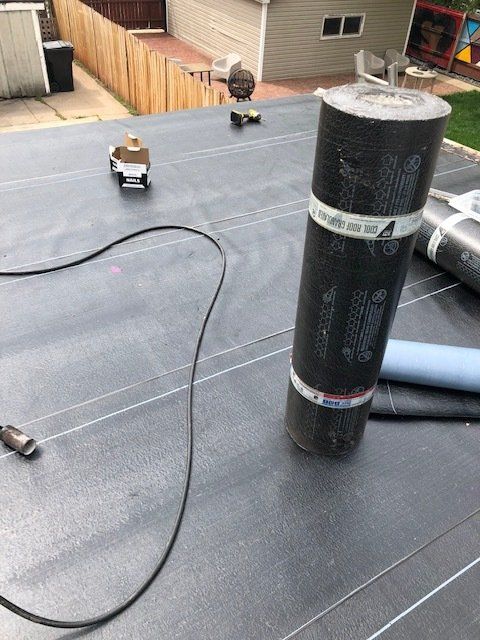 A roll of roofing material is sitting on top of a roof.