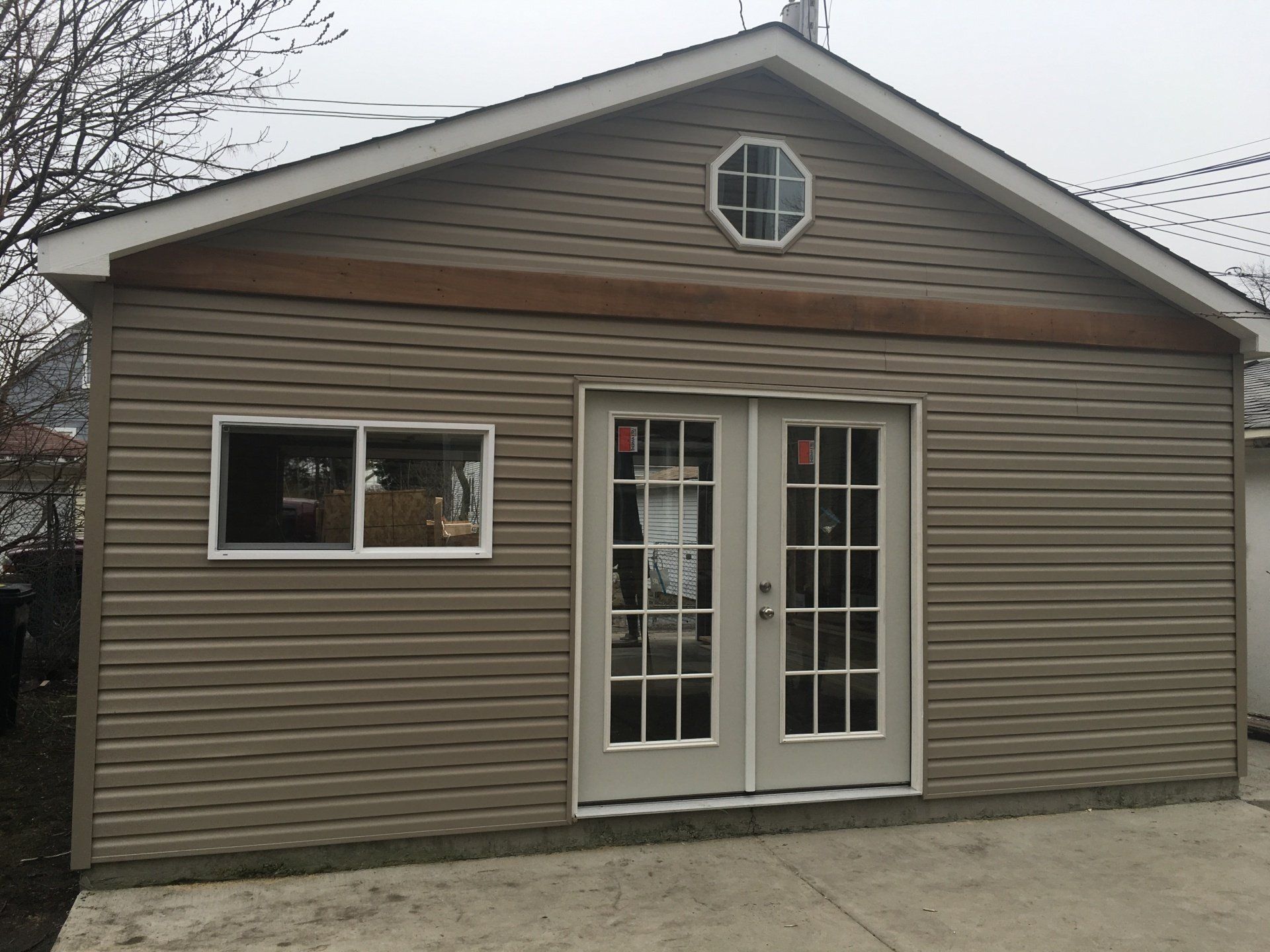 A small house with a window and french doors