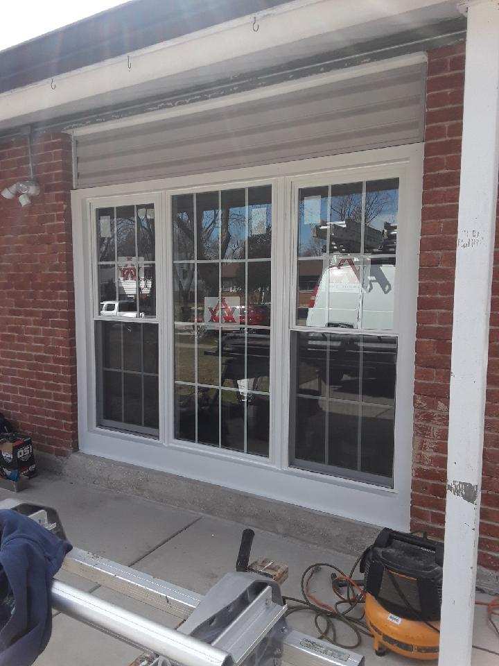 A brick building with a sliding glass door and a table saw in front of it.