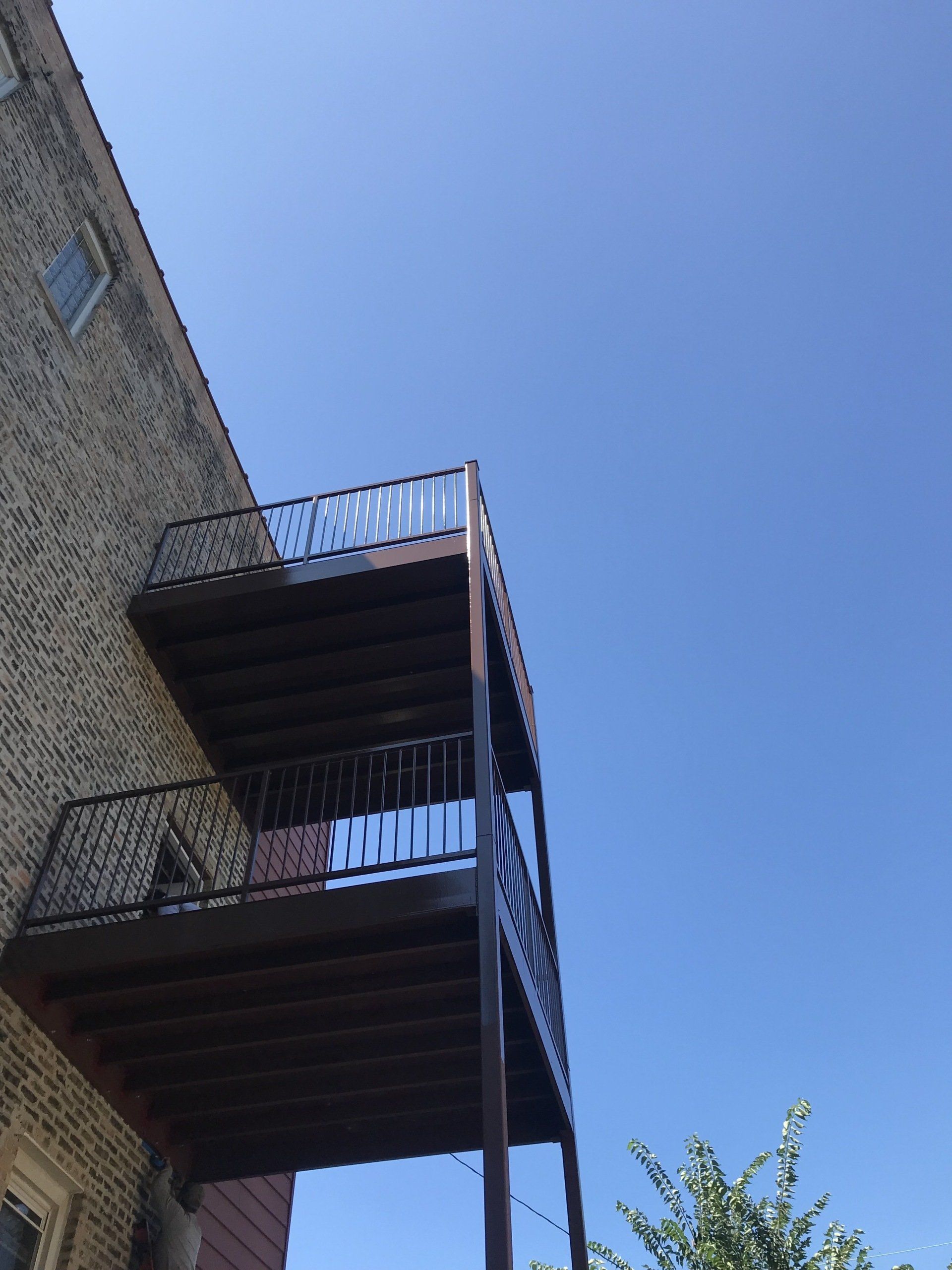 A balcony on the side of a building with a blue sky in the background