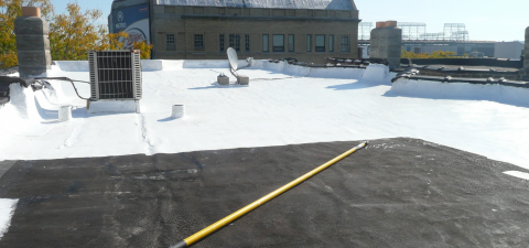 A yellow tape measure is sitting on top of a roof.