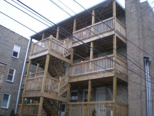 A brick building with a wooden deck and stairs