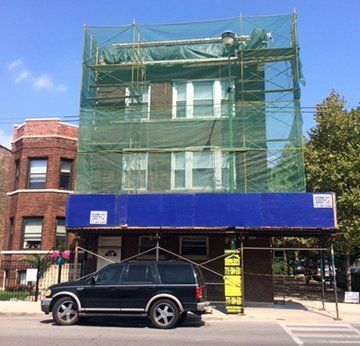 A black suv is parked in front of a building under construction