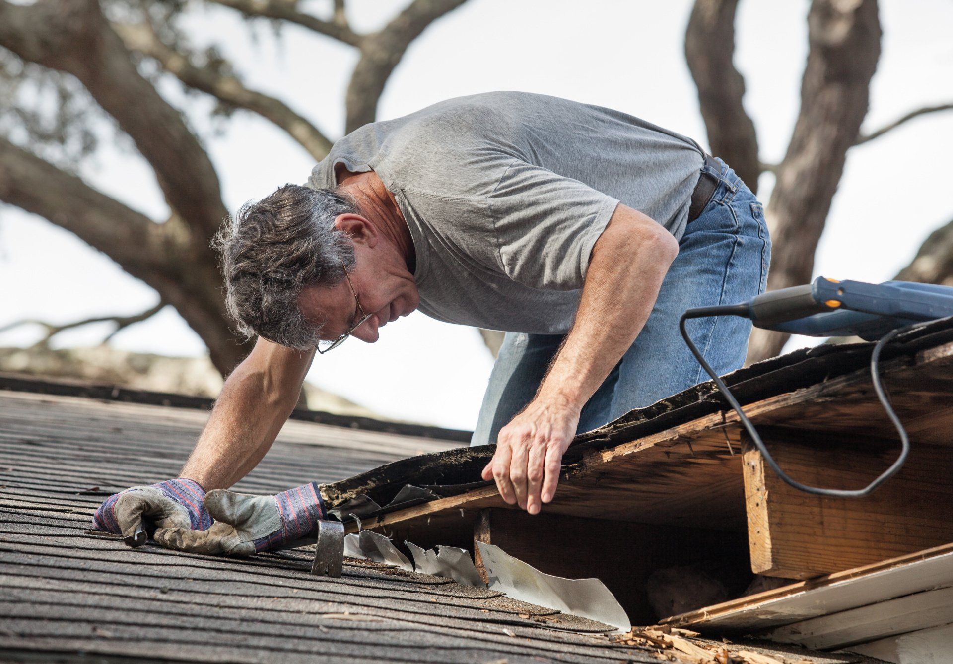 A man is working on the roof of a house.