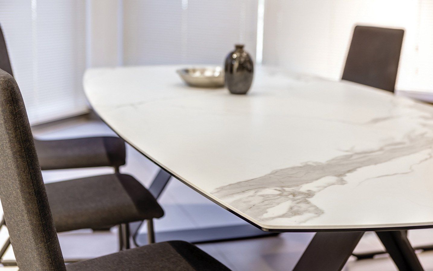 A dining room table with a marble top and chairs