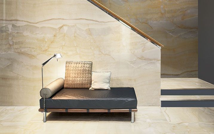 A couch is sitting in a room next to a staircase