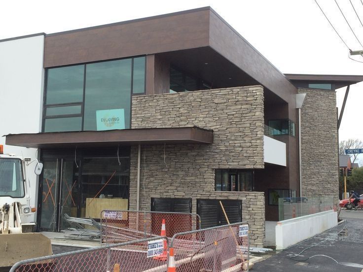 A white truck is parked in front of a building under construction