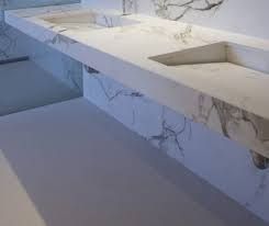A bathroom with two sinks and a marble counter top