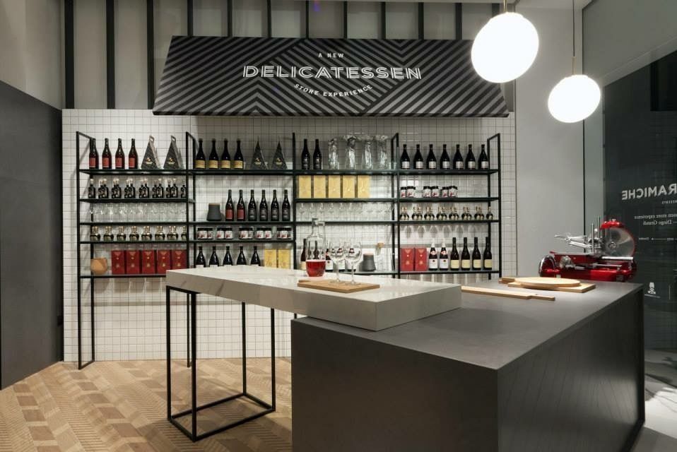 A kitchen with a table and shelves filled with bottles of wine