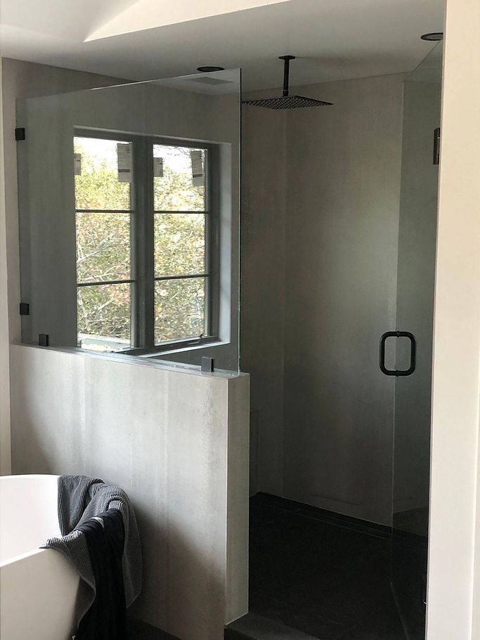 A bathroom with a walk in shower and a window