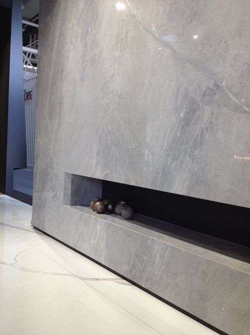 A gray wall with a shelf underneath it