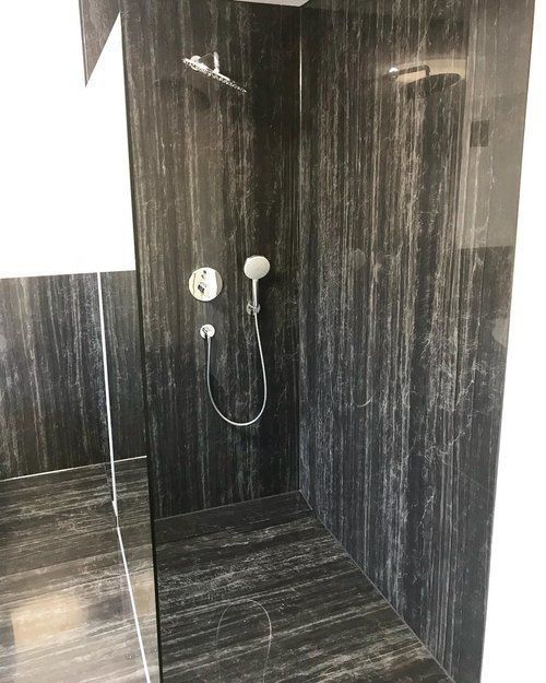 A bathroom with a walk in shower and a shower head