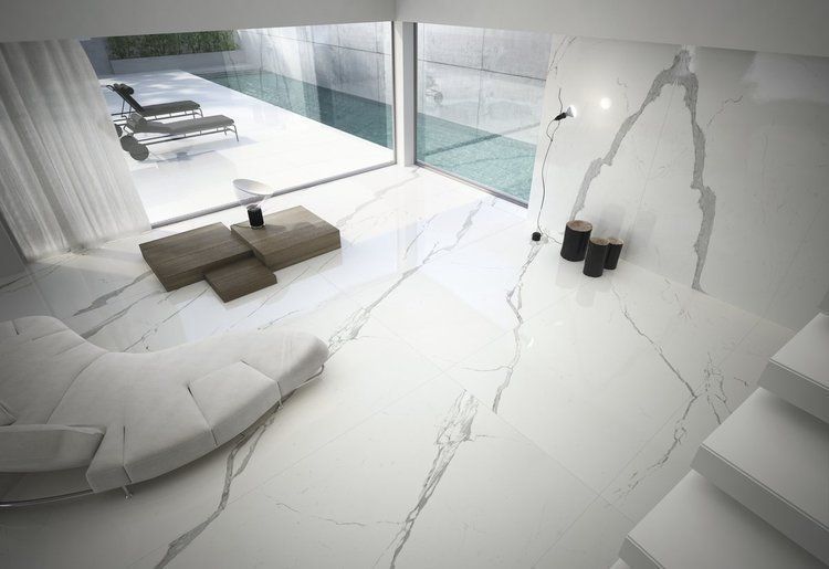 A living room with a white couch and stairs leading to a pool